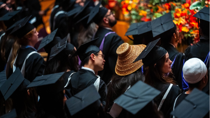Graduates wearing caps and gowns seated at a UBC ceremony