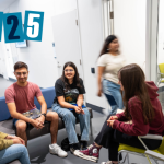 Group of psychology students talking and sitting in the Douglas Kenny Building, with '2025' text overlaid in the top left corner.